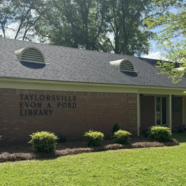 Taylorsville Evon A. Ford Library with brick exterior, dark roof, and landscaped surroundings.