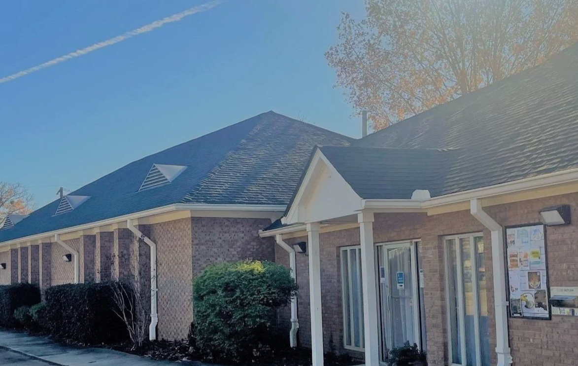 Florence Public Library with brick exterior, white columns, and autumn trees in the background.