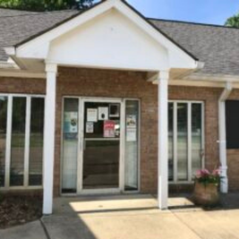 Florence Public Library entrance with brick exterior, white columns, glass doors, and potted flowers.