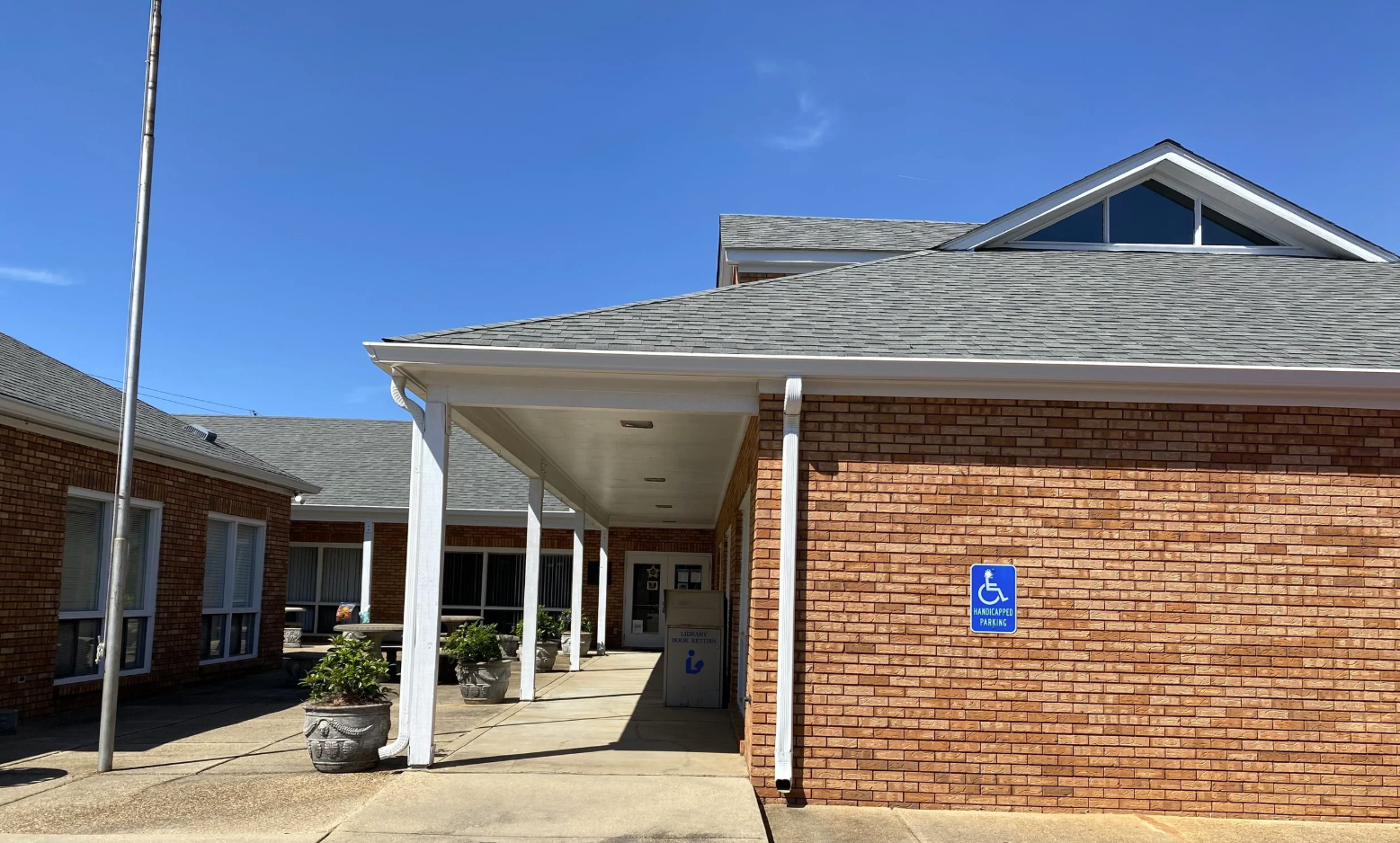 Floyd J. Robinson Memorial Library with brick exterior, white columns, and planters at entrance.