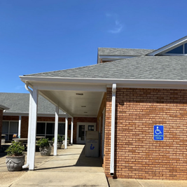 Floyd J. Robinson Memorial Library with brick exterior, white columns, and planters at entrance.