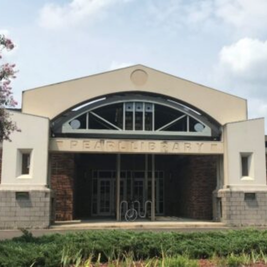 Pearl Public Library entrance with brick and concrete facade, glass doors, and trees on both sides.