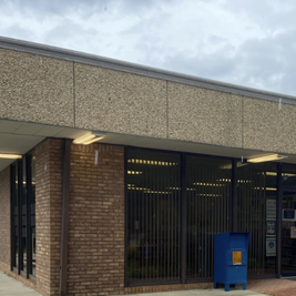 R.T. Prince Memorial Public Library with brick and concrete exterior, glass doors, and accessibility sign.