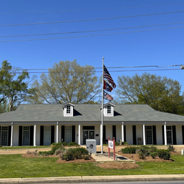 Exterior of Richland Public Library with white walls, columns, and three flags flying in front.